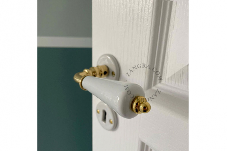 White porcelain and brass door handle.