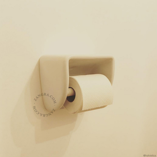 White porcelain toilet paper dispenser.