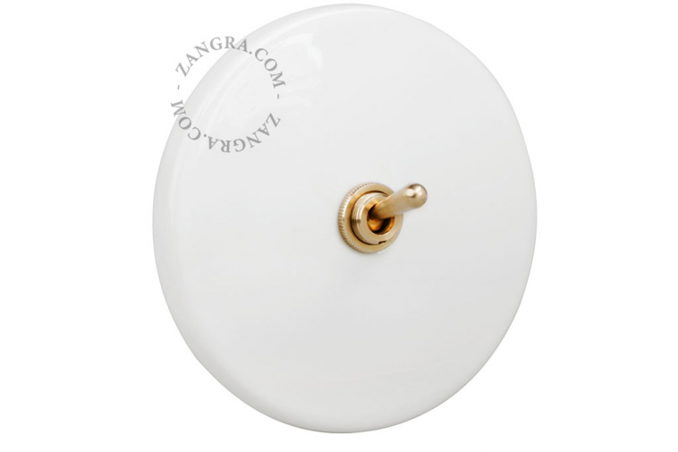 White porcelain switch with brass toggle switch.
