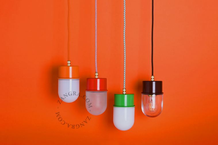 Orange pendant light with glass shade.
