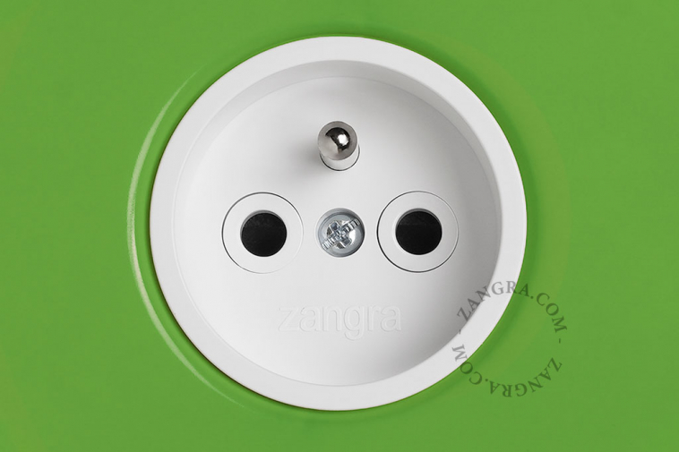 Green outlet & switch with raw brass pushbutton.