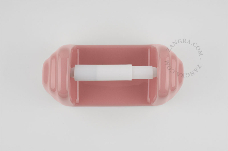 Pink porcelain toilet paper holder.