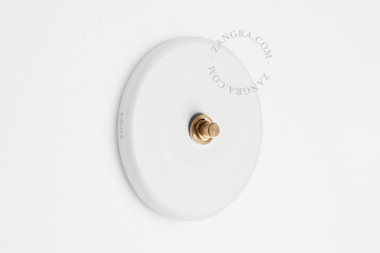 Round white porcelain light switch.