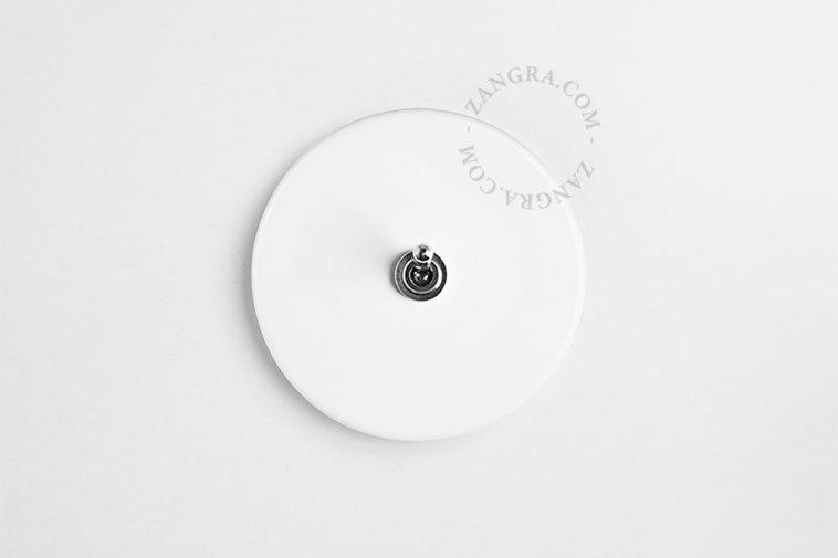 Round white porcelain light switch.