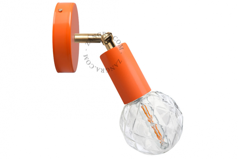 Orange adjustable wall light with brass arm.