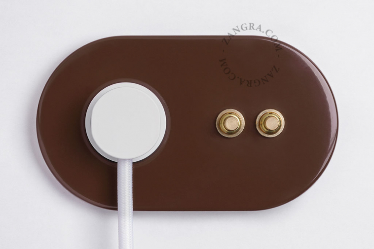 2 gold push buttons on brown integrated outlet.