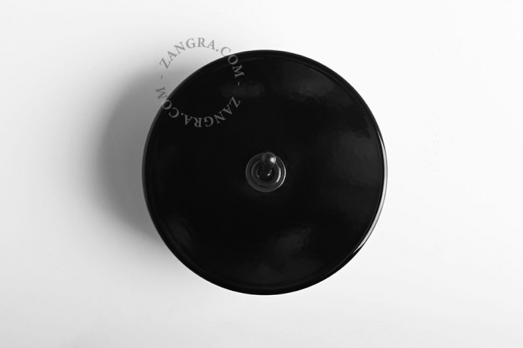 Round black light switch with black toggle.