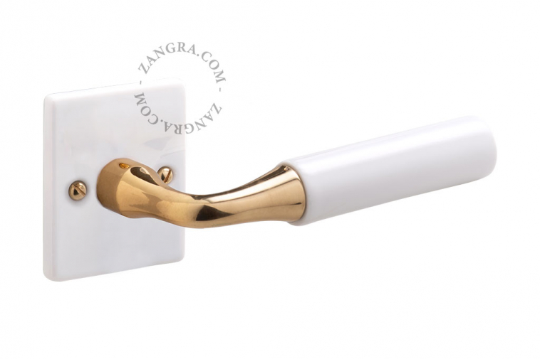 Door handle in white porcelain and brass.