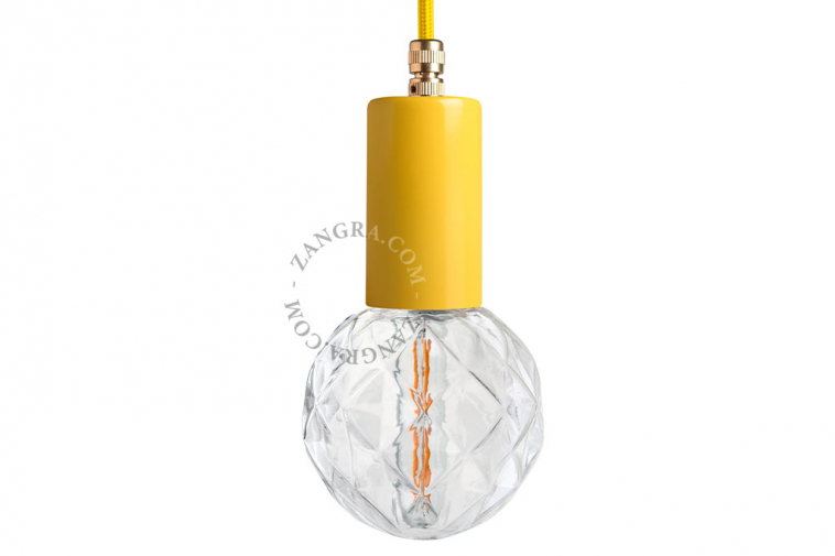 Yellow pendant light with exposed light bulb.