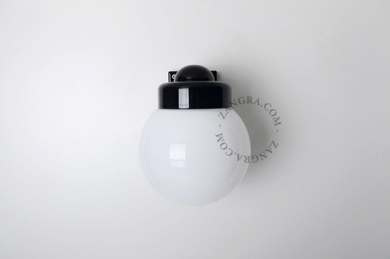 black porcelain wall light with glass globe for bathroom or outdoor use