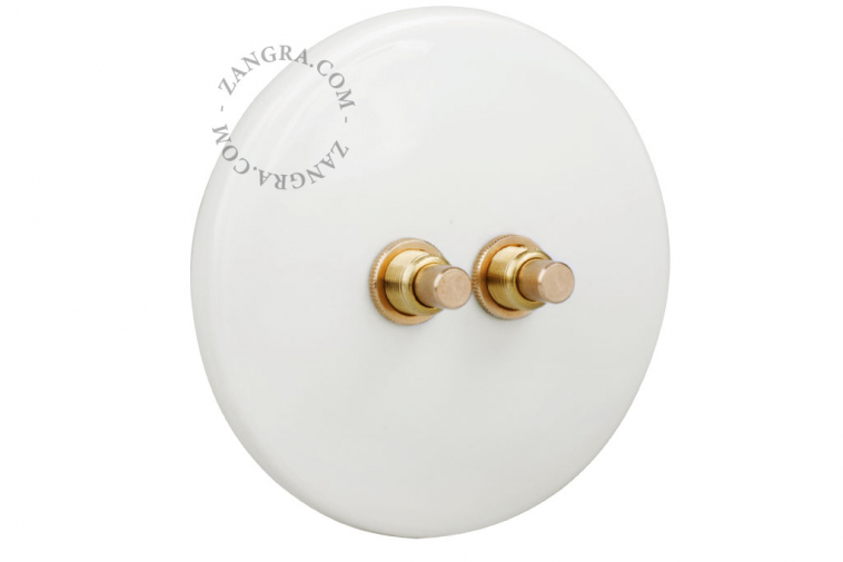 White porcelain switch with double brass pushbuttons.