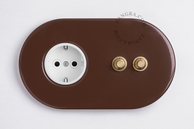 2 gold push buttons on brown integrated outlet.