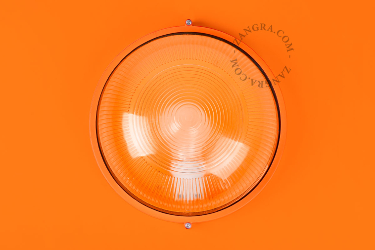 Ronde oranje verlichtingsarmatuur.