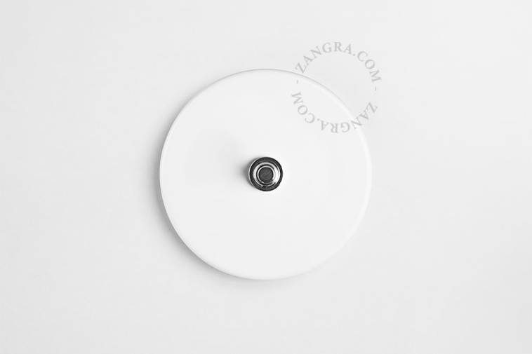 Round white porcelain light switch.