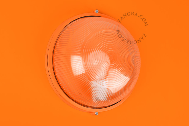 Ronde oranje verlichtingsarmatuur.