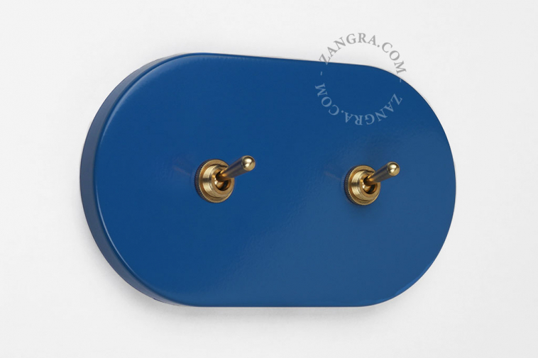 Blue light switch with double toggle in brass.