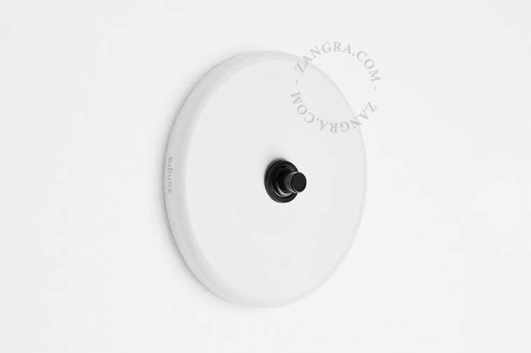 Round white porcelain light switch.