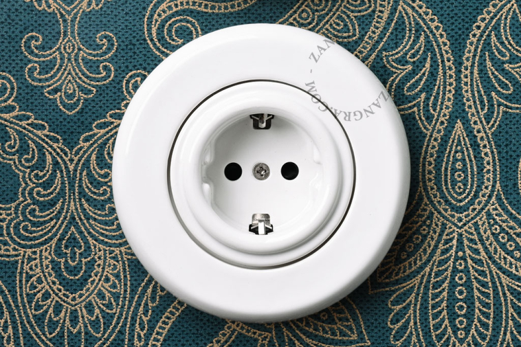 Unterputzsteckdose aus weissem Porzellan.