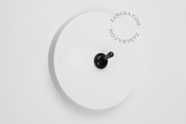 White round light switch with black toggle
