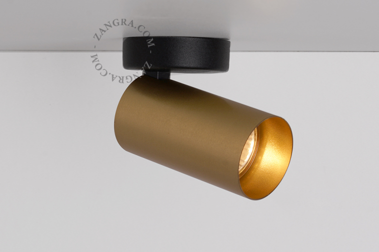 Surface mounted adjustable spotlight in brass.
