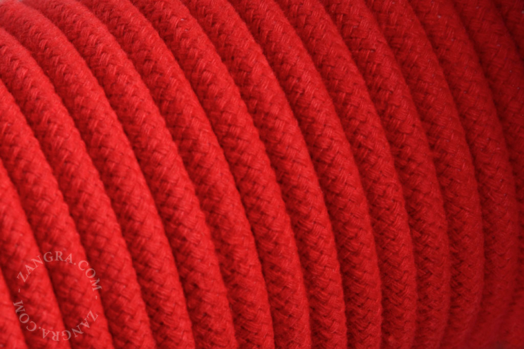 Electrical cable covered in red cotton.