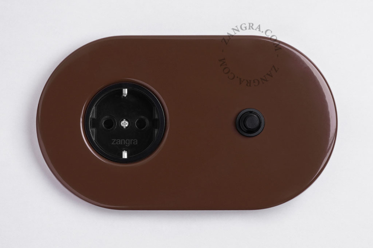 Brown flush mount outlet wirh black pushbutton.