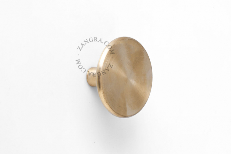 Round brass wall hook or door knob.