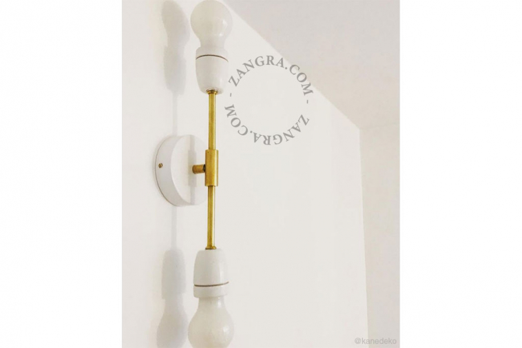 Black or white porcelain bowtie wall or ceiling light with brass arm.
