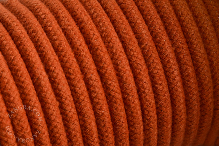 Electrical cable covered in orange cotton.