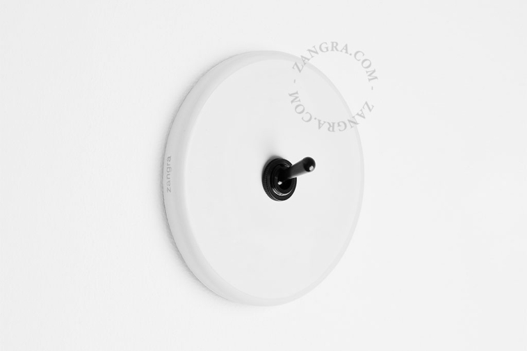 Round white porcelain light switch.