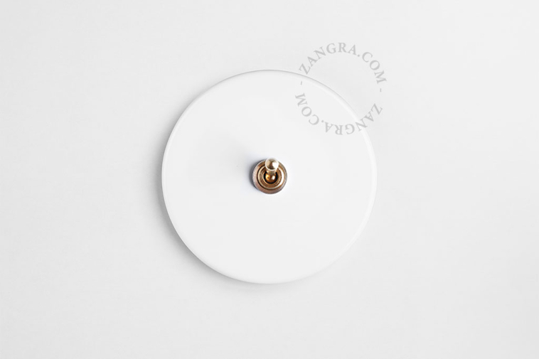 Round white porcelain light switch.