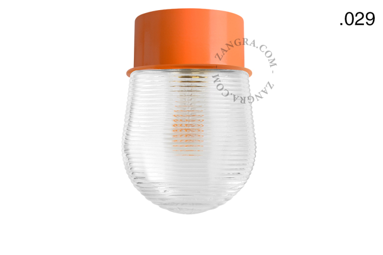 Orange ceiling light with glass shade.