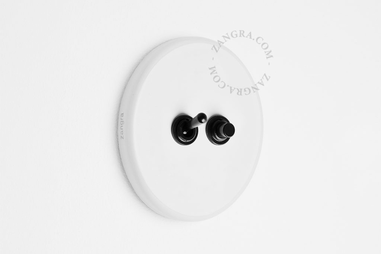 Round white porcelain light switch.