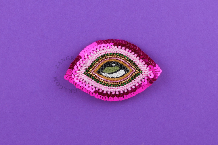 Pink eye brooch.