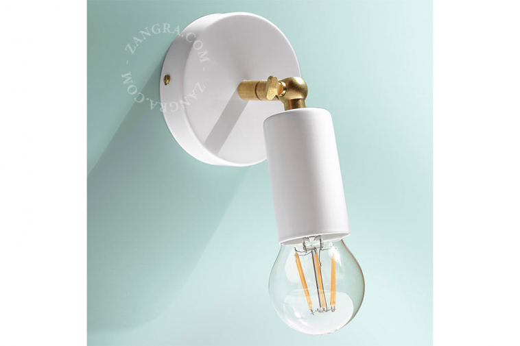 White adjustable wall light with brass arm.