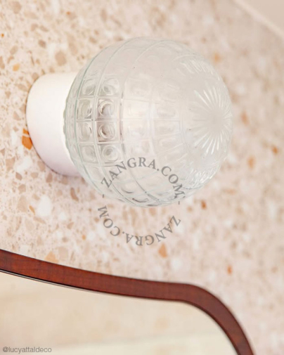 White porcelain wall light with glass globe for bathroom or outdoor use.