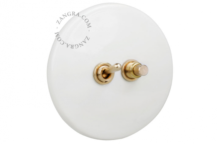 White porcelain switch with brass toggle & pushbutton.