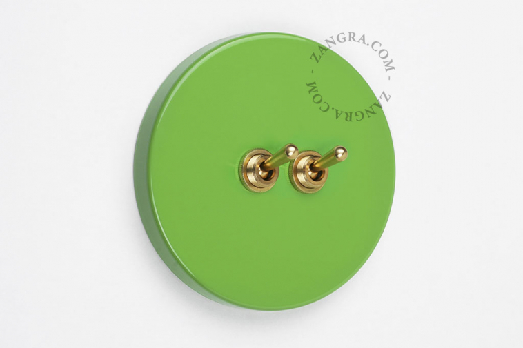 Round green and brass double light switch.