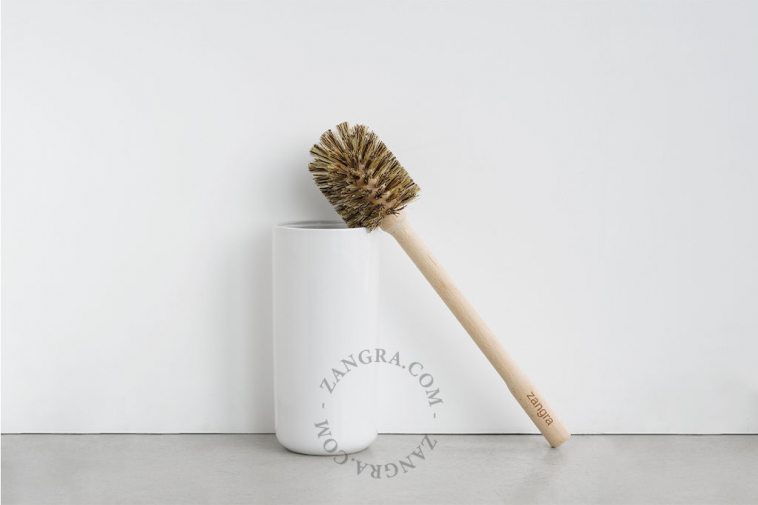 White porcelain toilet brush holder with wooden brush.