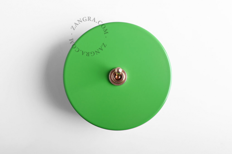Round green and brass light switch.