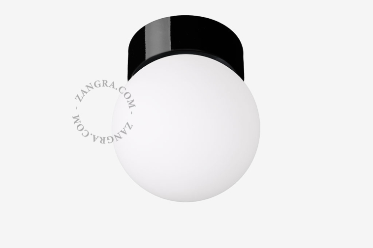 Lâmpada de porcelana preta com abajur de vidro.