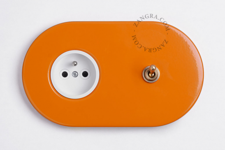 prise et interrupteur va-et-vient de couleur orange avec levier en laiton brut