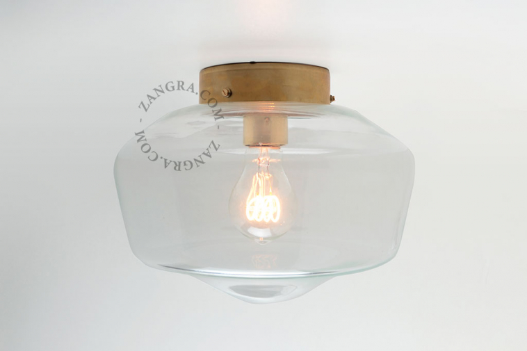 Schoolhouse style brass lamp with glass shade.
