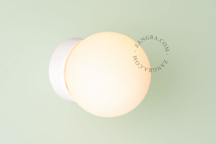 Lâmpada de porcelana branca com abajur de vidro.