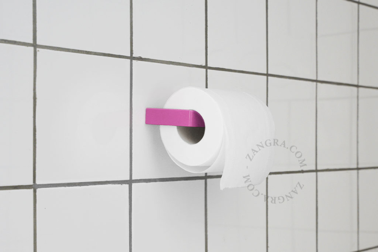 Pink metal toilet paper holder.