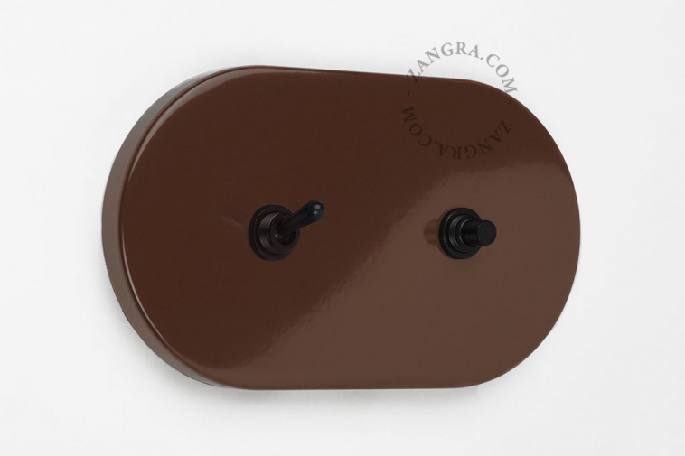 Large brown light switch with toggle and pushbutton.