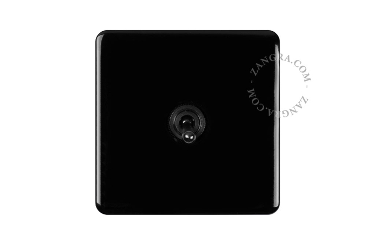 Vierkante lichtschakelaar met zwarte tuimelschakelaar.