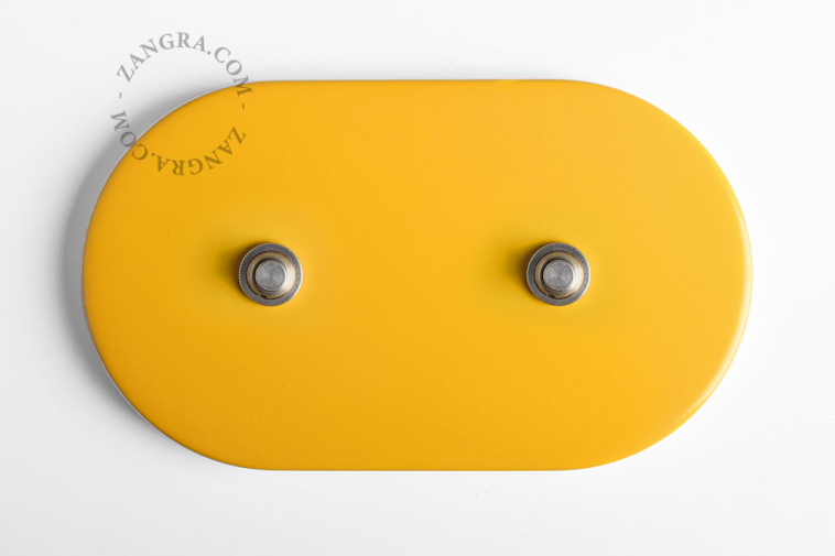 Schakelaar in de kleur geel met twee goudkleurige drukknoppen.