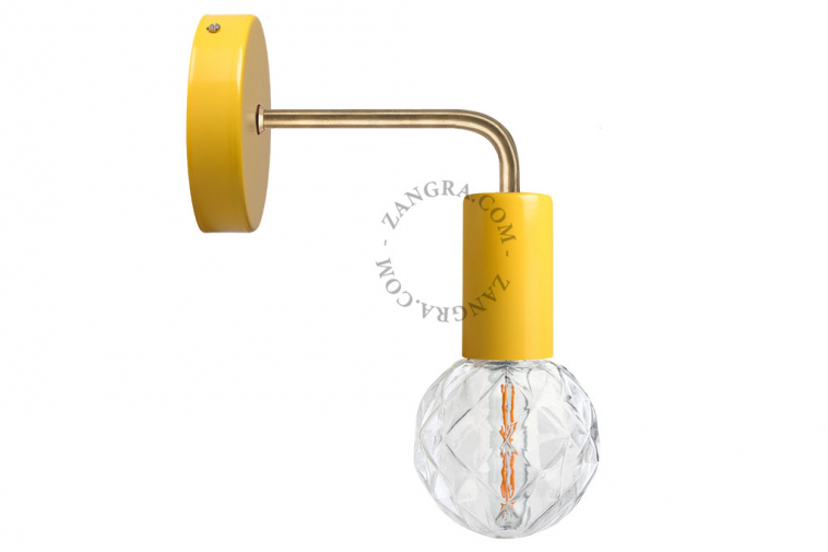 yellow wall light with brass arm